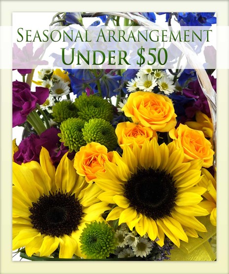 A colorful bouquet with sunflowers, yellow roses, green buds, purple and white flowers. Text reads, 