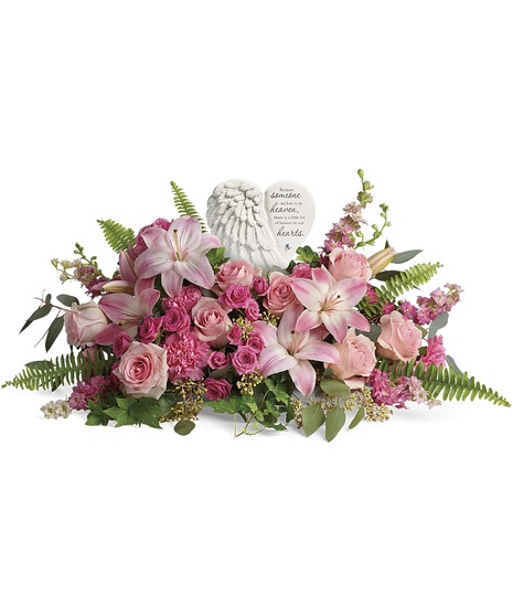 Floral arrangement featuring pink lilies and roses, with ferns and greenery. 