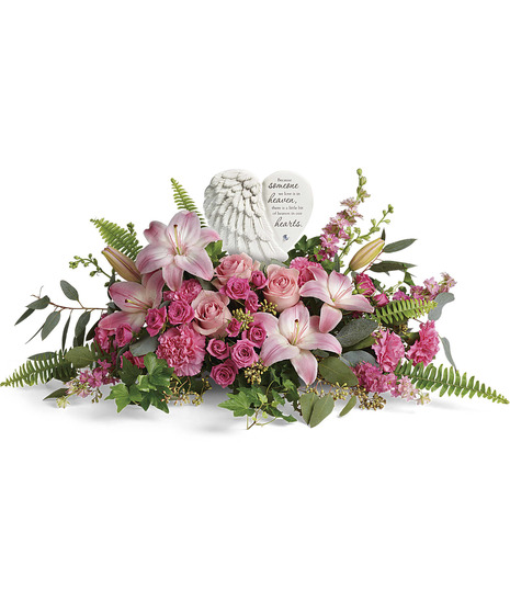 Floral arrangement featuring pink lilies and roses, with ferns and greenery. 