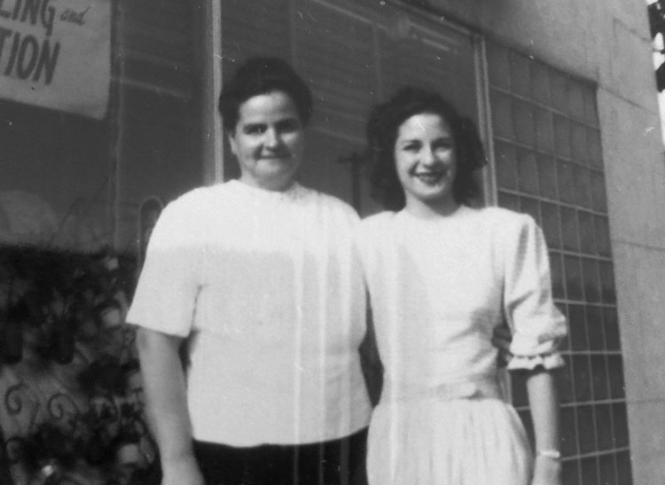 Two of the Mancuso sisters pose in front of the store's picture window in the mid-20th century